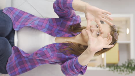 Vertical-video-of-Woman-making-heart-symbol-for-camera.